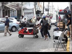 Film crew personnel preparing to shoot a scene of ‘Get Millie Black’ along a section of Harbour Street in downtown Kingston. 
