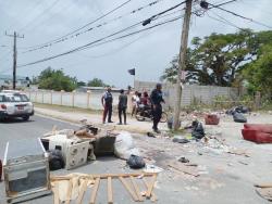 Police seek to clear the roadblock set up by yesterday by angry residents of Dalling Street in Savanna-la-Mar, Westmoreland, who protested the lack of electricity which they said they did not have from Sunday.