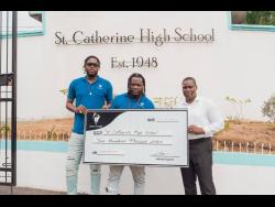 Ainsley ‘NotNice’ Morris (left) and Kram Medley (centre) present the symbolic cheque to Marlon Campbell, principal of St Catherine High School.