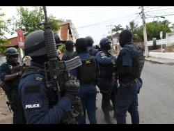 Police personnel in Spanish Town, St Catherine on Tuesday following a flare-up of violence.