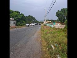 Police cordon off the scene where the bodies of two men were found in a car in Portmore Villas yesterday.
