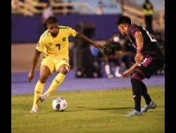 Jamaica’s Leon Bailey (left) takes on Mexico’s Jesus Gallardo during their Concacaf Nations League match at the National Stadium in Kingston on Tuesday.
