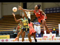 Jamaica wing attack Nicole Dixon-Rochester (left) intercepts a pass to Trinidad and Tobago goal defence Aniecia Baptiste (right) during a test match between the teams at the National Indoor Sports Centre in St Andrew on Wednesday, October 20, 2021.