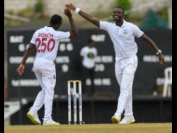 West Indies bowlers Jayden Seales (right) and Kemar Roach  celebrate the last dismissal Syed Khaled Ahmed of Bangladesh, during the fourth day of the second Test cricket match against Bangladesh at the Daren Sammy Cricket Ground in Gros Islet, Saint Lucia, yesterday.