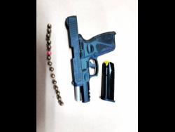 The black taurus 9mm semi-automatic pistol which was seized at the house occupied by the woman and her two sons in Duncans, Trelawny, on Tuesday morning.