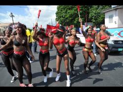 Revellers march during the Downtown Kingston Carnival parade on East Heroes Circle.