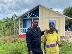 National sprinter Yohan Blake (left) and Irene Morgan standing before her new house recently. Blake financed the construction as Morgan’s Mother’s Day gift. 