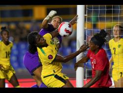 Jamaica goalkeeper Rebecca Spencer (back) punches the ball ahead of teammate Vyan Sampson (centre), and Canada's Kadeisha Buchanan during their Concacaf Women's Championship semi-final match in Monterrey, Mexico on Thursday.