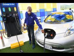 Richard Gordon, manager of business development at the Jamaica Public Service Company, charges an electric vehicle during the commissioning of the first public electric vehicle charging station at Boots service station in Drax Hall, St Ann last May.