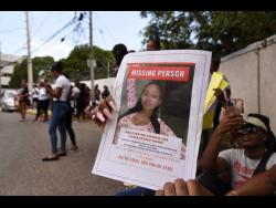 A protester holds a photo of missing social media influencer Donna-Lee Donaldson during a recent demonstration along Chelsea Avenue, St Andrew. 