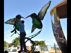 Artist  Jerome Marshall applies finishing touches to one of the four floats that was used in the Emancipation Day parade on Monday.