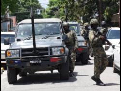 Members of the security forces along James Street in central Kingston.