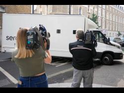 Journalists film a prison van moving into Westminster Magistrates Court in London on Wednesday. A 20-year-old man has been charged with intending to injure or alarm the queen under the Treason Act following an incident on Christmas Day 2021 at Windsor Castle. 