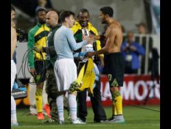 Argentina’s Lionel Messi (left) changes his shirt with Jamaica’s Joel McAnuff at the end of the Copa America Group B soccer match at the Sausalito Stadium in Vina del Mar, Chile, in 2015. Argentina won the game 1-0.
