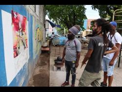 Rasta City Reading Club co-founder Oneil Coke (left) and Live Child lead artist on the Paint The City mural project. 