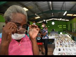 Ruth Morgan tries on a pair of reading glasses during a free medical camp hosted by the High Commission of India in association with the Prime Minister Andrew Holness’ constituency office, the Indian community of doctors and Indian pharmaceutical companies. 