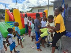 Ruschelle Thomas assisting children at the treat in Hampton Green, Spanish Town, St Cathetine on Sunday.