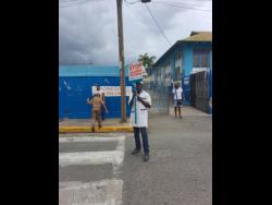 Traffic warden Stephen Williams on the job in the vicinity St Catherine Primary School, along White Church Street in Spanish Town last Thursday.