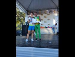 Danielle Terrier (left) and Brandon Kerr, winners of the MBC 5K Charity Run, display their prizes after the event at the Sangster International Airport in Montego Bay on Saturday.