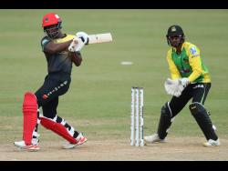St Kitts and Nevis Patriots’ Andre Fletcher (left) plays a shot as wicketkeeper Amir Jangoo of Jamaica Tallawahs watches during their Caribbean Premier League (CPL) match at the Queen’s Park Oval in Port-of-Spain, Trinidad, yesterday. Tallawahs lost by eight wickets.