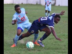 Jaheem Frazer (right) of Jamaica College is bundled off the ball by St Catherine High’s Rolando Redman during their ISSA/Digicel Manning Cup football match at the Spanish Town Oval on Friday. The match ended 0-0 and St Catherine will face neighbours St Jago at the same venue today.