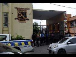 Concerned persons outside the gates of Kingston Technical High School yesterday, following the fatal stabbing of a female student by another.