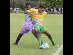 Irwin High’s Abraham Quest (left) and Green Pond High’s Trayvon Haughton battle for the ball during their ISSA/Digicel daCosta Cup football match at Irwin recently. Irwin High won 2-0.