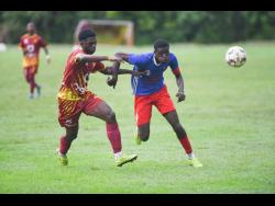 Ronaldo Thompson (left) of Wolmer’s Boys’ School attempts to ward off the effort of Camperdown’s Devante McCrea during their ISSA/Digicel Manning Cup match at the Alpha Institute last Friday. Camperdown won 1-0.