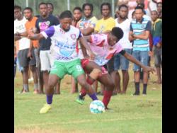 William Knibb Memorial High’s prolific striker Mark Lewis (left) battles for the ball with Spot Valley High’s Javane Clarke during a recent daCosta Cup match. Lewis was prominent in yesterday’s match against Cedric Titus, which drew 0-0.