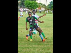Tevin Afflick (left) of Calabar High shields Michael Pennant of  St George’s College from the ball during their ISSA/Digicel Manning Cup match at Winchester Park, St. George’s College yesterday. St George’s won 2-1.