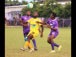 Garvey Maceo’s attacking midfielder Cleo Clarke (centre) battles with Tiguan Gilbert (left) and Christopher Rowe during their ISSA/Digicel daCosta Cup match at Foga Road on Tuesday. Clarke is one of the leading players for Merron Gordon and Garvey Maceo this season and played a role in their 2-1 victory.