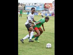 Cavalier’s Kyle Ming (left) tries to get around Kemar Mullings of Humble Lions during their Jamaica Premier League match at Anthony Spaulding Sports Complex in April.
