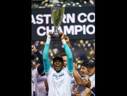 Philadelphia Union’s Andre Blake raises the trophy after they defeated New York City FC in the MLS Eastern Conference  final on Sunday. The Union won 3-1.