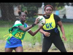 Maxfield Park goal shooter Scherae Palmer (left) collects a pass in front of Gordon Town’s goalkeeper Sateva Taylor, during their netball encounter at the Pembroke Hall Community court in the SDC Four-In-One competition.