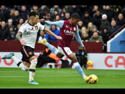 Aston Villa’s Leon Bailey (right) scores the opening goal during the English Premier League  match between Aston Villa and Manchester United at Villa Park in Birmingham, England on  Sunday. At left is Manchester United’s defender Lisandro Martinez. 