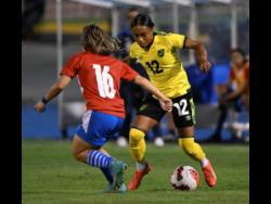 Jamaica’s Siohban Wilson (right) gets ready for a challenge from Paraguay’s Ramona Martinez during their friendly international match at the National Stadium yesterday. Paraguay won 2-1.