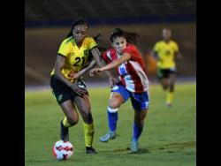 Jamaica’s Cheyna Matthews (left) dribbles past Paraguay’s Camila Arrieta during their friendly international match at the National Stadium on Sunday. Paraguay won 2-1. 