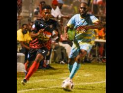 Rushike Kelson of Arnett Gardens FC dribbles around Damion Binns of Waterhouse FC during the Boom El Clasico at the Anthony Spaulding Complex recently. Arnett Gardens won the inagurual staging of the event, which was played as a treat for fans before the start of the Jamaica Premier League.
