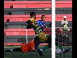 Rashawn Livingston (right) of Molynes United scores the winning goal in their 1-0 victory over Vere United FC as goalkeeper Rojae Williams and defender Donavan Clarke (foreground) scramble during their Jamaica Premier League (JPL) match at Anthony Spaulding Sports Complex yesterday.