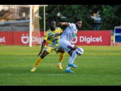 Rohane Brown (right) of Chapelton Maroons turns away from Damion Binns of Waterhouse during Sunday  night’s Jamaica Premier League match at the Stadium East field. The Maroons won 1-0 with Brown scoring in the 20th minute. 