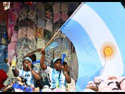 Kadeen ‘Guzzo Boss’ Richards (right) celebrates Argentina’s second goal with fellow supporters on Beckford Street, downtown Kingston. 
