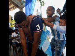 Argentina supporters playfully rip off the jersey of France fan Joshua Vassell at Pier 1 in Montego Bay, St James, on Sunday. Argentina defeated France 4-2 on penalties to win the World Cup after an enthralling 3-3 tie in extra time.