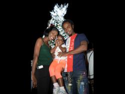 Tajae Brown (left) and Nico Angus (right) with their daughter Nickaylia at the Christmas tree lighting ceremony at St William Grant Park on Tuesday.
