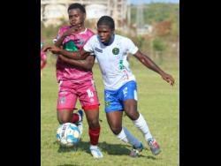 Chapelton Maroons’ Theon Cupee (left) battles with Vere United’s Tavis Grant during their Jamaica Premier League encounter at the Wembley Centre of Excellence yesterday. The match drew 0-0.