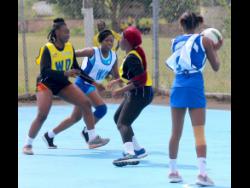  Netball action between Clarendon (Black) and St James (Blue) in the Social Development Commission’s  4-in-1 community competition at the GC Foster College recently.

 