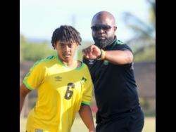 Jamaica Under-17 coach Merron Gordon (right) instructs midfield substitute Jordan Mangatal before he enters the field of play against Vere United on Thursday at the Wembley Centre of Excellence.