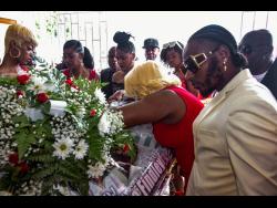 Gary Findley (right), brother of the late Ray ‘DJ Raevas’ Findley, comforts his mother, Claudette Findley, as she cries viewing her son’s body.