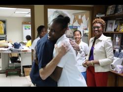 Danae Pryce shares a warm embrace with Bruce Bicknell, managing director of Tank-Weld. Looking on are Lorretta Ricketts (right), Merl Grove High School’s acting principal, and Pryce’s schoolmates Takara Levy (left) and Aaliyah Woodhi.