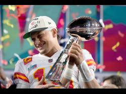 Kansas City Chiefs quarterback Patrick Mahomes holds the trophy after their win against the Philadelphia Eagles in the NFL Super Bowl 57 football game yesterday in Glendale, Arizona. The Kansas City Chiefs defeated the Philadelphia Eagles 38-35.
