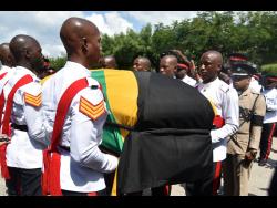 Credit: Kenyon Hemans Pallbearers carry the body of former Commissioner of Police Lucius Thomas after his thanksgiving service at the Boulevard Baptist Church in St Andrew yesterday.